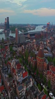 Amsterdam, Hollanda şehri. Şehir merkezinde elektrikli tekneleri olan kanalların havadan görüntüsü. İnsansız hava aracı Amsterdam bahar manzarası dar eski evler, kanallar. Eski merkez hava görüntüsü oluşturuluyor.