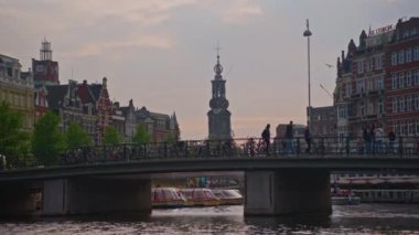 Hollanda, Amsterdam, 24 Haziran 2024: Geleneksel evler, kanallar, bisikletler, kentsel ulaşım. Avrupa 'da bir şehrin turizm merkezi. Şehirde dolaşan ve gezen bir sürü insan..