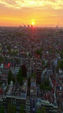 Amsterdam, Hollanda şehri. Şehir merkezinde elektrikli tekneleri olan kanalların havadan görüntüsü. İnsansız hava aracı Amsterdam bahar manzarası dar eski evler, kanallar. Eski merkez hava görüntüsü oluşturuluyor.