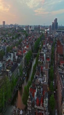 Amsterdam, Hollanda şehri. Şehir merkezinde elektrikli tekneleri olan kanalların havadan görüntüsü. İnsansız hava aracı Amsterdam bahar manzarası dar eski evler, kanallar. Eski merkez hava görüntüsü oluşturuluyor.