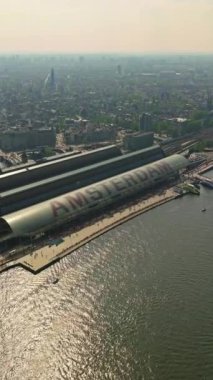 Amsterdam, Hollanda şehri. Şehir merkezinde elektrikli tekneleri olan kanalların havadan görüntüsü. İnsansız hava aracı Amsterdam bahar manzarası dar eski evler, kanallar. Eski merkez hava görüntüsü oluşturuluyor.