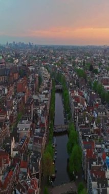 Amsterdam, Hollanda şehri. Şehir merkezinde elektrikli tekneleri olan kanalların havadan görüntüsü. İnsansız hava aracı Amsterdam bahar manzarası dar eski evler, kanallar. Eski merkez hava görüntüsü oluşturuluyor.