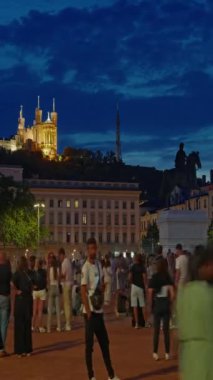 Dikey video. Bellecour Meydanı 'nda gün batımında Lyon şehir merkezindeki ana yer olan Kral 14. Louis, Lyon, Fransa' nın heykeliyle. Zaman Uygulaması.
