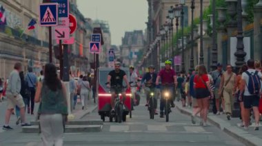 Paris 'in en uzun ve ünlü caddesi, Şanzelize' nin doğal uzantısı. Bisikletçiler ve kalabalık. Bisikletli ana cadde, millet. Şehir merkezindeki şehir trafiği Fransa, Paris, 30 Temmuz 2024.