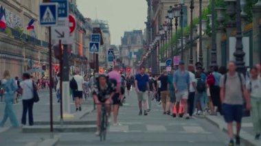 Paris 'in en uzun ve ünlü caddesi, Şanzelize' nin doğal uzantısı. Bisikletçiler ve kalabalık. Bisikletli ana cadde, millet. Şehir merkezindeki şehir trafiği Fransa, Paris, 30 Temmuz 2024.