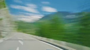 İsviçre 'de Alp Vadisi' nde dağ yolunda araba sürerken. İsviçre Alplerinde araba kullanmak. Sürücülerin bakış açısından ve arabadan çekilmiş. İsviçre, Avrupa 'da güzel dağlık doğada seyahat etmek.