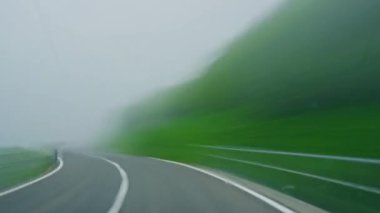 İsviçre 'de Alp Vadisi' nde dağ yolunda araba sürerken. İsviçre Alplerinde araba kullanmak. Sürücülerin bakış açısından ve arabadan çekilmiş. İsviçre, Avrupa 'da güzel dağlık doğada seyahat etmek.