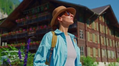 Mavi gömlekli ve şık şapkalı çekici bir kız tatilini Alp çayırlarında yalnız geçirir. Sırt çantalı bir turist inanılmaz manzarayla İsviçre 'yi geziyor..