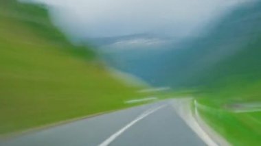 İsviçre 'de Alp Vadisi' nde dağ yolunda araba sürerken. İsviçre Alplerinde araba kullanmak. Sürücülerin bakış açısından ve arabadan çekilmiş. İsviçre, Avrupa 'da güzel dağlık doğada seyahat etmek.