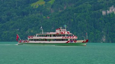 İsviçre 'de İsviçre Bayrağı ile birlikte İsviçre Gölü' ndeki vapur gemisinin havadan görüntüsü. İsviçre yaz turizmi merkezi. Turkuaz mavi su.