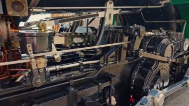 Antika buharlı tren lokomotifi. Çift lokomotif treni duman sızdırıyor. Demiryolundaki eski model tren. Yakın plan. İsviçre.