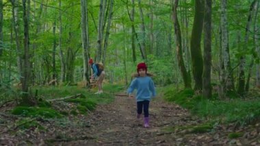 Sevimli küçük bir kız sonbaharda ormanda koşar ve etrafındaki her şeye bakar ve etrafındaki dünyayı öğrenir..