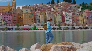 Menton, Fransa 'da arka plandaki renkli evlerde yürüyen güzel bir kadın. Cote dAzur, Fransa.