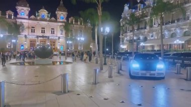 Monaco, Monte-Carlo, 05 Şubat 2025: Monako 'daki ünlü Casino cephesi, lüks arabalar, gece aydınlatması. Spor arabalar merkez meydandan geçiyor..