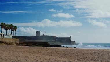 Portekiz, Carcavelos sahilinden deniz feneri kulesi olan Aziz Julian Kalesi. Carcavelos 'taki Atlantik okyanus dalgaları plajı.