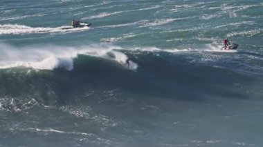 Portekiz 'de, Nazare sörf alanında büyük bir dalgaya eşlik eden büyük bir dalganın havadan görüntüsü..