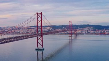 Kızıl 25 Nisan Köprüsü Kırmızı süspansiyonu gün batımında. Tagus Nehri, Lizbon, Portekiz.