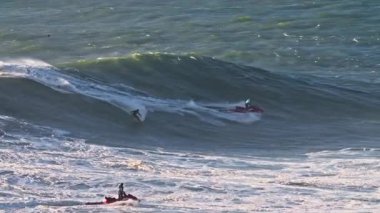 Portekiz 'de, Nazare sörf alanında büyük bir dalgaya eşlik eden büyük bir dalganın havadan görüntüsü..