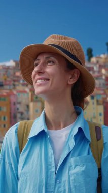 Menton, Fransa 'da arka plandaki renkli evlerde şapkalı güzel bir kadın duruyor. Cote dAzur, Fransa.