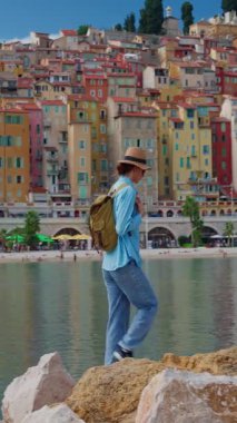 Menton, Fransa 'da arka plandaki renkli evlerde şapkalı güzel bir kadın duruyor. Cote dAzur, Fransa.