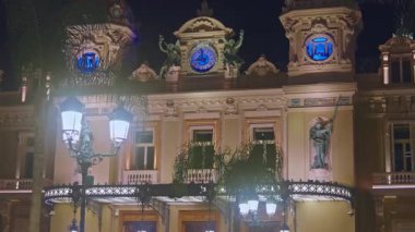 Monaco, Monte Carlo, 05 Mart 2025: Monako 'daki ünlü Casino cephesi, lüks arabalar, gece aydınlatması. Spor arabalar merkez meydandan geçiyor..