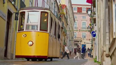 Lizbon, Portekiz, 25 Şubat 2025: Lizbon caddesindeki sarı tramvay turist mıknatısı ve şehrin sembolü.