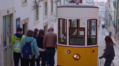 Lizbon, Portekiz, 26 Şubat 2025: Lizbon 'da dar bir sokakta bulunan eski sarı tramvay,.