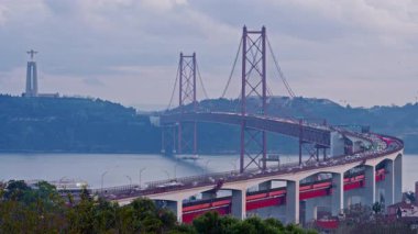 Gün batımında Miradouro do Bairro do Alvito 'dan Tagus Nehri' ne turist bakış açısı, 25 Nisan Köprüsü 'nde gün batımında trafik. Lizbon, Portekiz. Bir yolcu gemisi köprünün altından geçiyor. Zaman Uygulaması.