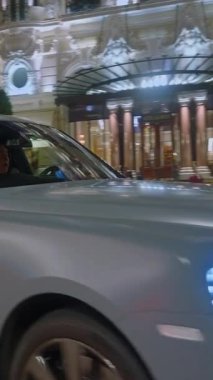 Monaco, Monte-Carlo, 05 Şubat 2025: lüks araba Royce 'u çekiyor, gece aydınlatması. Spor arabalar merkez meydandan geçiyor..