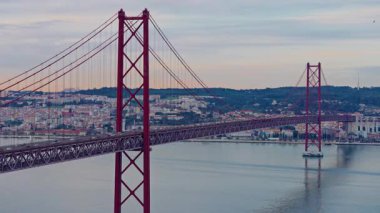 Kızıl 25 Nisan Köprüsü Kırmızı süspansiyonu gün batımında. Tagus Nehri, Lizbon, Portekiz.