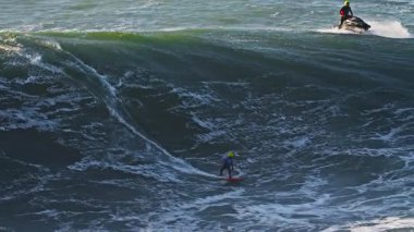 Portekiz 'de, Nazare sörf alanında büyük bir dalgaya eşlik eden büyük bir dalganın havadan görüntüsü..