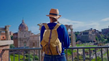 Şapkalı ve sırt çantalı bir turist kız Roma, İtalya 'daki Roma Forumu' nun kalıntılarını inceliyor..