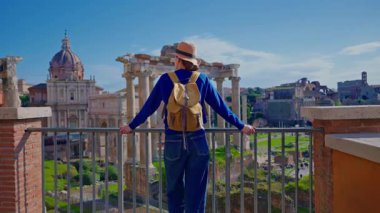 Şapkalı ve sırt çantalı bir turist kız Roma, İtalya 'daki Roma Forumu' nun kalıntılarını inceliyor..