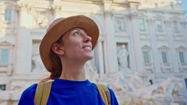 Roma 'da sırt çantalı ve şapkalı bir turist Trevi Çeşmesi' nin manzarasına bakıyor. Roma, İtalya 'da seyahat.