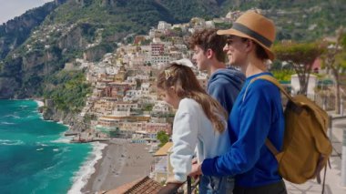 Amalfi Sahili 'nde tatilde olan dört kişilik bir aile, İtalya' nın ünlü turistik kasabası Positano 'nun manzarasının tadını çıkarıyor..