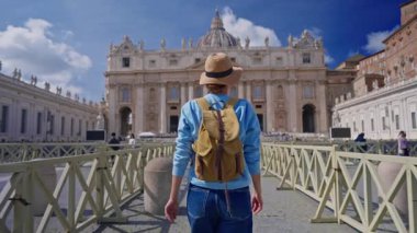 Şapkalı ve sırt çantalı bir turist kız Vatikan, Roma 'daki ikonik St. Peters Meydanı' na hayran..