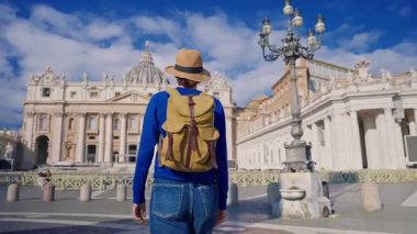 Şapkalı ve sırt çantalı bir turist kız Vatikan 'daki St. Peters Bazilikası' na gider..