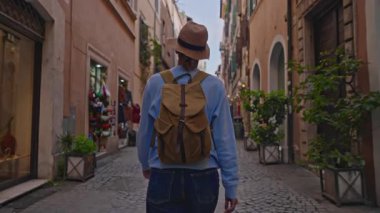 Roma, İtalya 'da sırt çantalı bir kadın turist eski bir caddede yürüyor. Roma 'nın eski şehrine bakan bir kız..