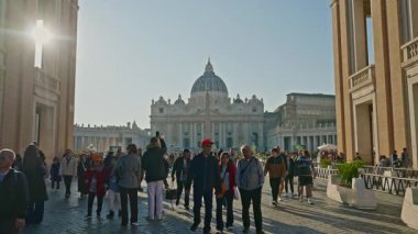 Roma, İtalya, 29.04.2025: Saint Peter Meydanı, Aziz Peter Bazilikası ve Vatikan Obelisk uzak mesafede. Sokakta yürüyen turistler Via della Conciliazione.