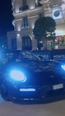 Monaco, Monte-Carlo, 05 Şubat 2025: Lüks arabalar Porsche, gece aydınlatması. Spor arabalar merkez meydandan geçiyor..