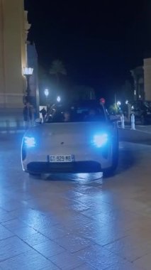 Monaco, Monte-Carlo, 05 Şubat 2025: Lüks arabalar Porsche, gece aydınlatması. Spor arabalar merkez meydandan geçiyor..