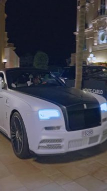 Monaco, Monte-Carlo, 05 Şubat 2025: lüks araba Royce 'u çekiyor, gece aydınlatması. Spor arabalar merkez meydandan geçiyor..