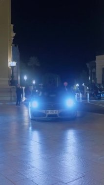 Monaco, Monte-Carlo, 08 Şubat 2025: Lüks araba ferrari, gece aydınlatması. Ferrari spor arabası merkez meydandan geçiyor..