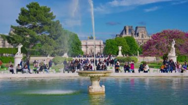 Tuileries Garden, Paris, Fransa, 30.05.2025. İnsanlar parkta yürüyor ve güzel bir çeşme işliyor..