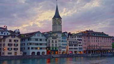 Limmat Nehri 'ndeki İsviçre. Nehir ve kule saatlerinin yanındaki renkli binalar. Zürih, İsviçre, 25.05.2025.