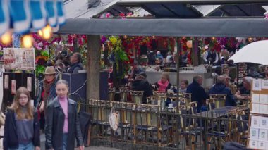 Paris, Fransa, 24.06.2025: Paris 'in popüler kafe terası Paris sokaklarında çiçeklerle süslenmiş.