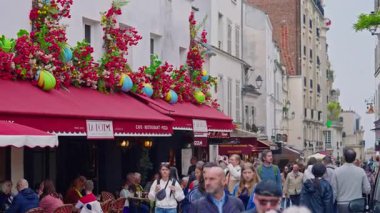 Paris, Fransa, 24.06.2025: Paris 'in popüler kafe terası Paris sokaklarında çiçeklerle süslenmiş.
