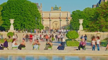 Tuileries Gardenin, Paris, Fransa. İnsanlar parkta yürüyor ve çeşmenin yanındaki sandalyelerde oturuyorlar. Zaman ayarlı. Paris, Fransa, 30.05.2025.
