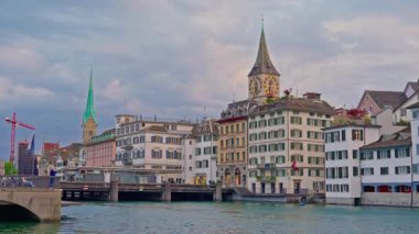 Limmat Nehri 'ndeki İsviçre. Nehir ve kule saatlerinin yanındaki renkli binalar. Zürih, İsviçre, 25.05.2025.