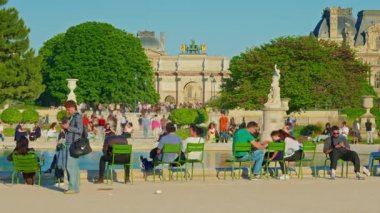Tuileries Garden, Paris, Fransa, 30.05.2025. İnsanlar parkta yürüyor ve çeşmenin yanındaki sandalyelerde oturuyorlar. Zaman Uygulaması.